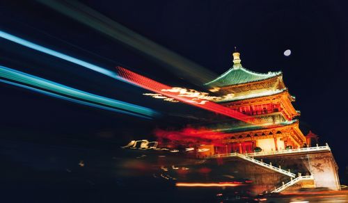 Low angle view of illuminated building against sky at night