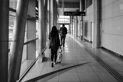 Rear view of people walking in corridor
