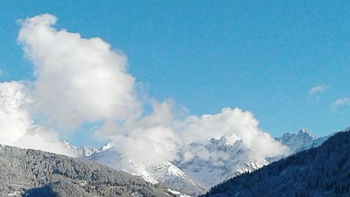 Scenic view of snowcapped mountains against blue sky