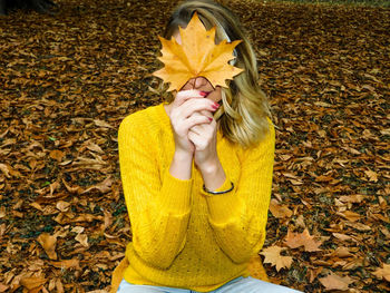 Low section of woman with autumn leaves
