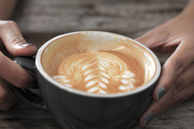 Close-up of hand holding coffee cup