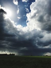 Scenic view of storm clouds over field