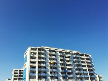 Low angle view of modern building against clear blue sky