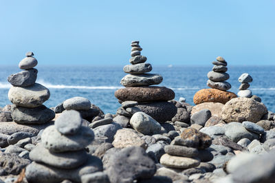 Stack of stones on rocky shore at sea