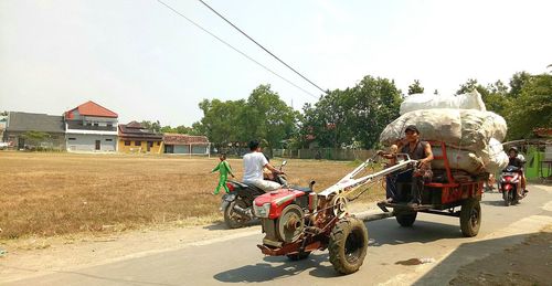 Man cycling on road against sky