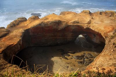 Rock formations by sea against sky