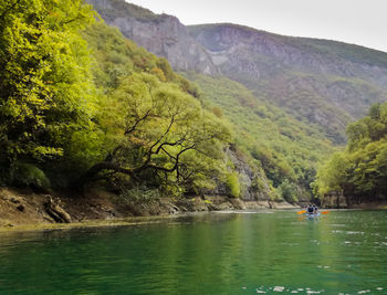 Scenic view of river amidst mountains against sky