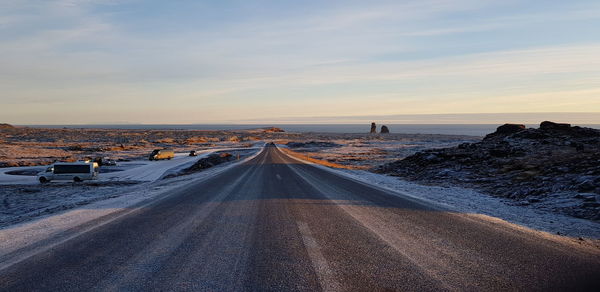 Panoramic view of road by sea against sky during sunset