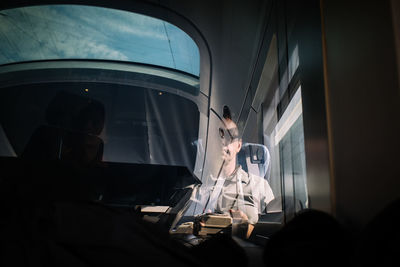 Man seen through glass traveling in train