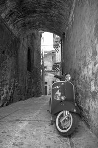 Motorcycle in tunnel amidst buildings