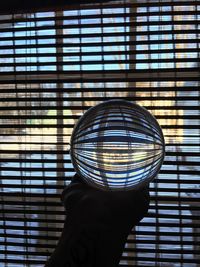 Close-up of hand holding glass window