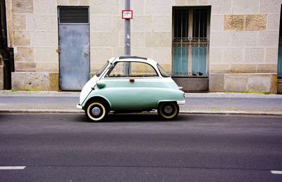 Small car on street against building