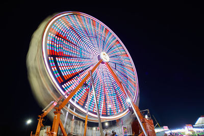 Low angle view of illuminated ferris wheel at night