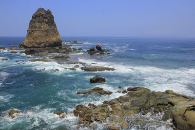 Scenic view of rocks in sea against sky