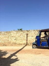Bicycle parked on sand against clear blue sky