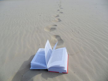 High angle view of open book on beach