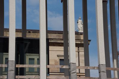 Low angle view of statue against building in city