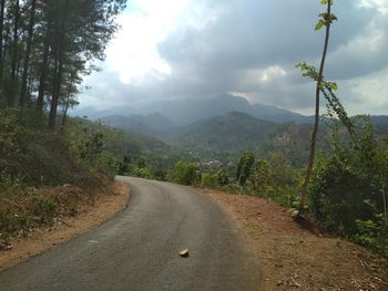 Road amidst green landscape against sky