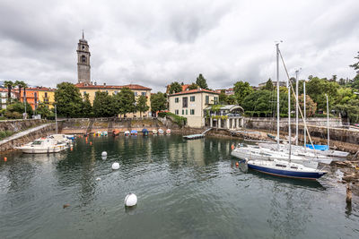 Boats moored in river against buildings