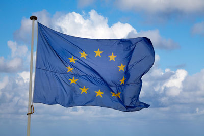 Low angle view of flag against blue sky