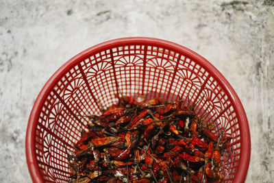 High angle view of red chili peppers in basket on table