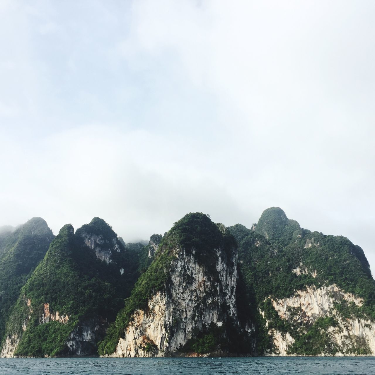 nature, beauty in nature, rock formation, tranquility, water, scenics, rock - object, mountain, tranquil scene, sea, day, outdoors, waterfront, sky, no people, physical geography, cliff