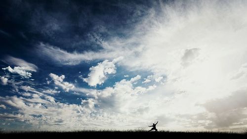 Scenic view of field against cloudy sky