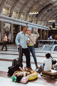 Bored family with luggage waiting at train station