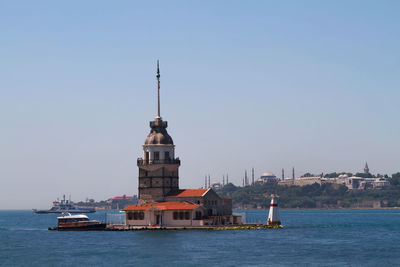 Building by sea against clear sky