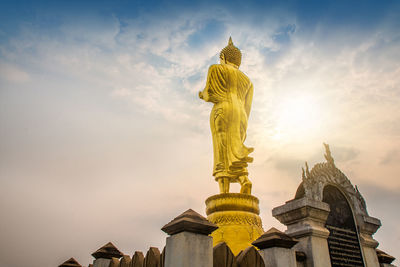 Low angle view of statue against building against sky