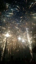 Low angle view of firework display at night