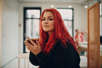 Portrait of beautiful young woman standing indoors