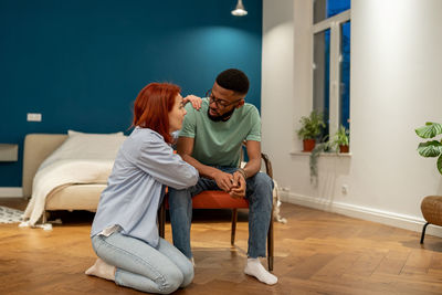 Side view of woman sitting on sofa at home