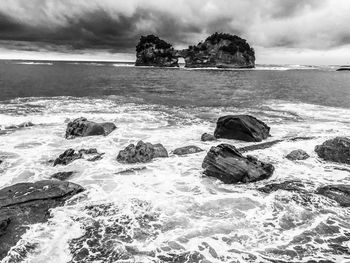 Scenic view of rocks on beach against sky