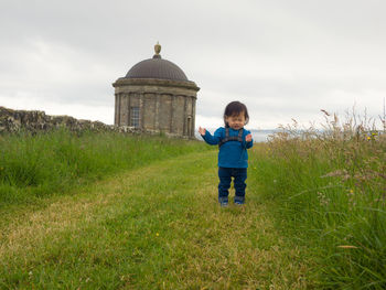 Girl standing on field against mussenden temple at downhill demesne