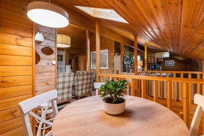 Dining room in a cozy wooden house. rural style room with table, chairs, cupboard and decoration