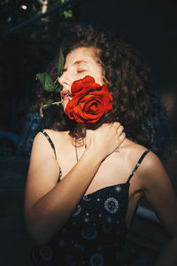 Midsection of woman holding red rose