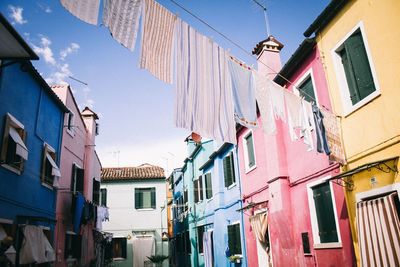 Low angle view clothes hanging amidst buildings