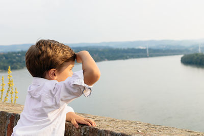 Side view of boy looking at river