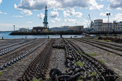 Chains at harbor against cloudy sky