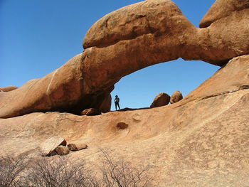 Low angle view of rock formations against clear blue sky