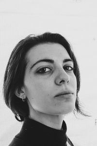 Close-up portrait of young woman against wall