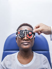 Optometrist adjusting the optometry equipment during study of the eyesight of a black woman