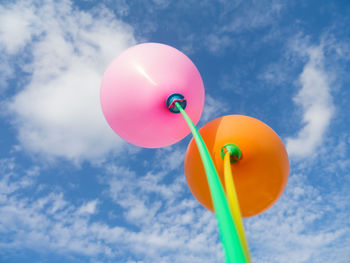 Low angle view of colorful balloons against blue sky