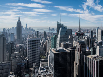 Skyscrapers in city against cloudy sky
