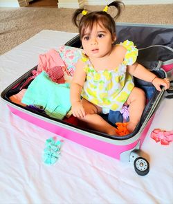 High angle view of cute baby girl sitting on floor