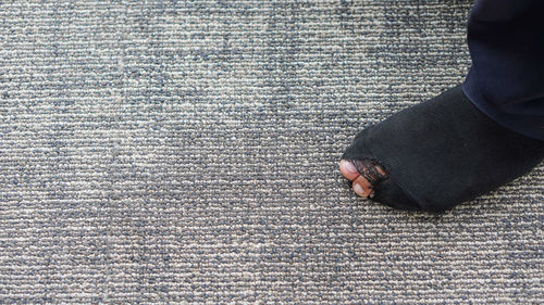 Low section of man standing on carpet