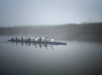 People in lake against sky