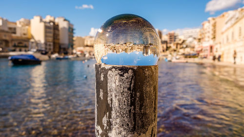 Close-up of cityscape and water against sky