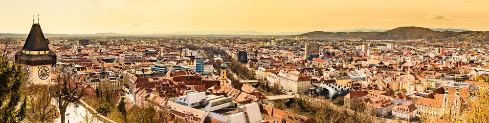 Panoramic view at graz city with his famous buildings. river mur, clock tower, art museum, town hall